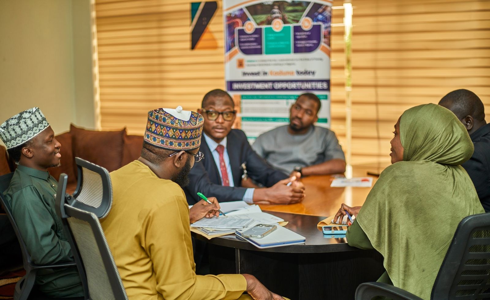 Officials seated around a table in a working stakeholder meeting