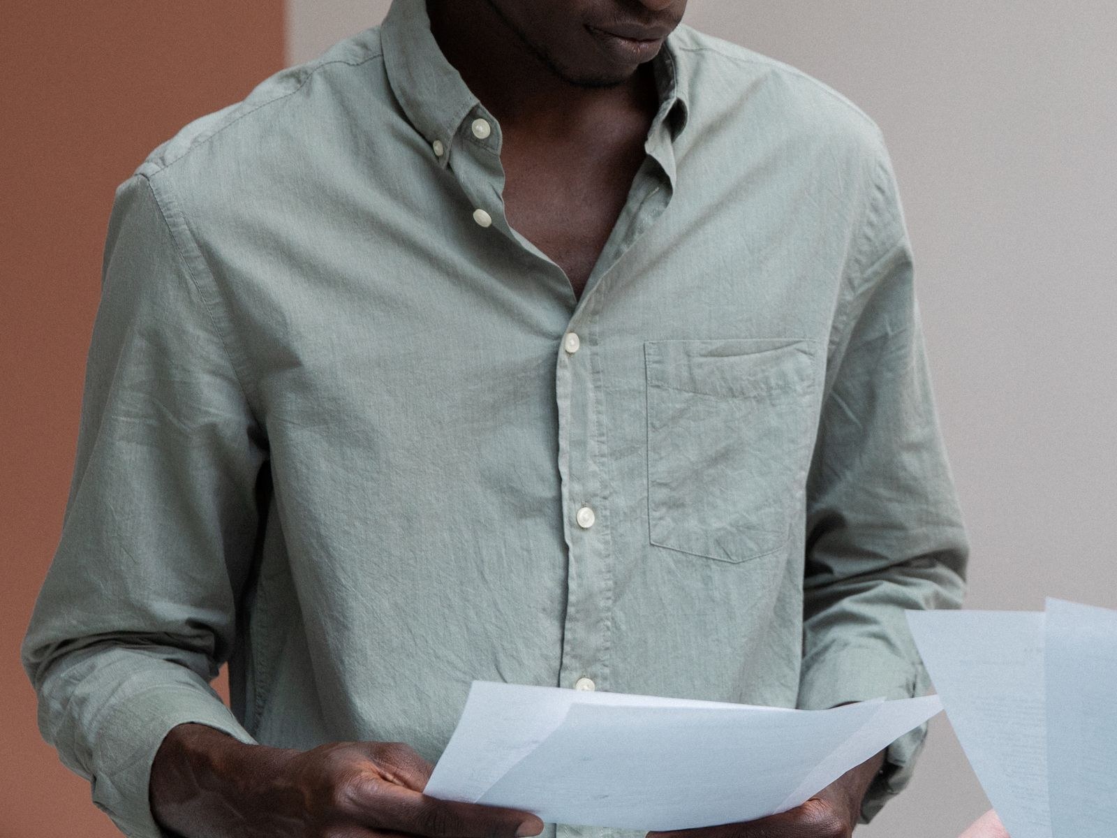 A man reading closely through a set of documents